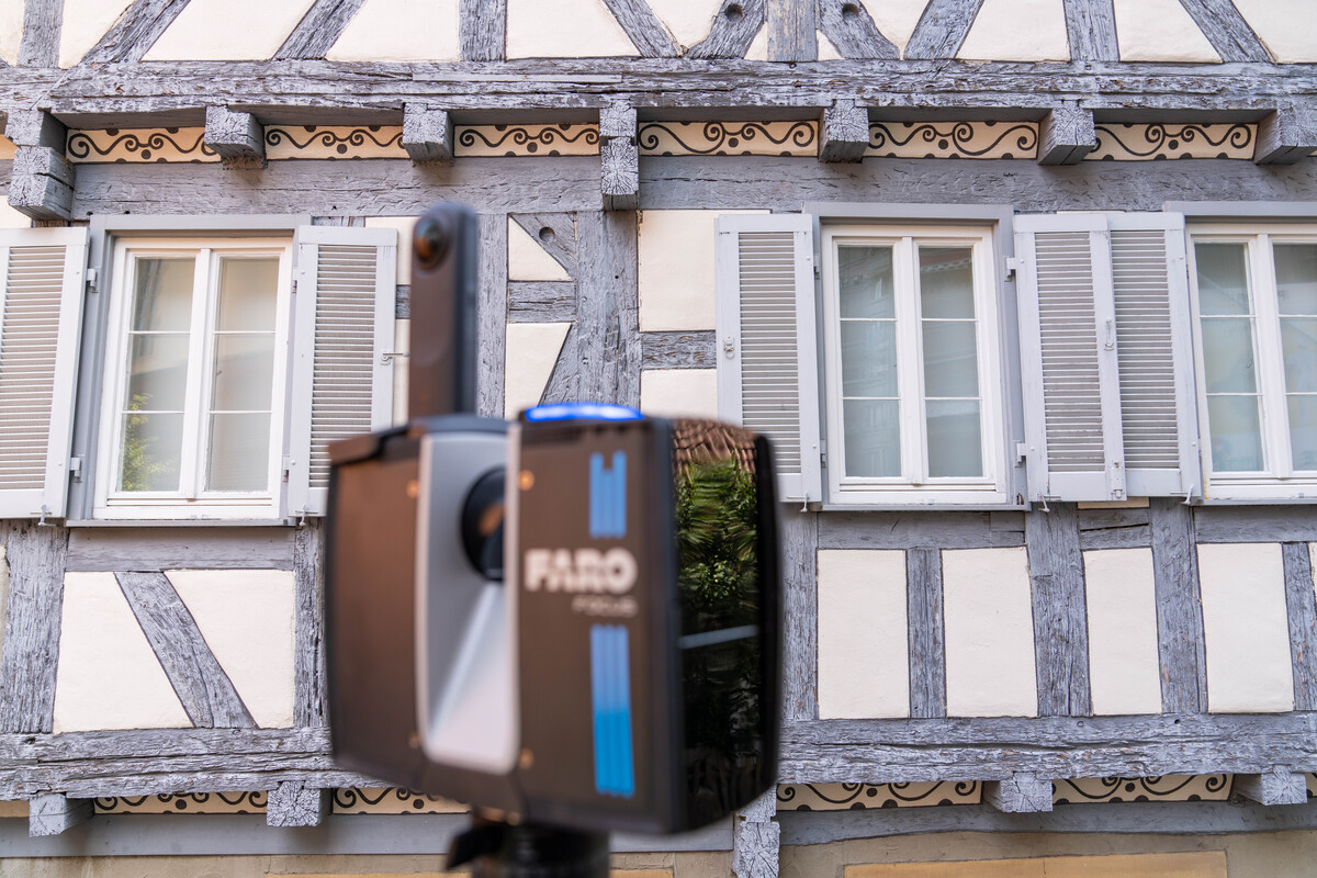 Eine Fachwerkhausfassade mit blau verziertem Gerät im Vordergrund.