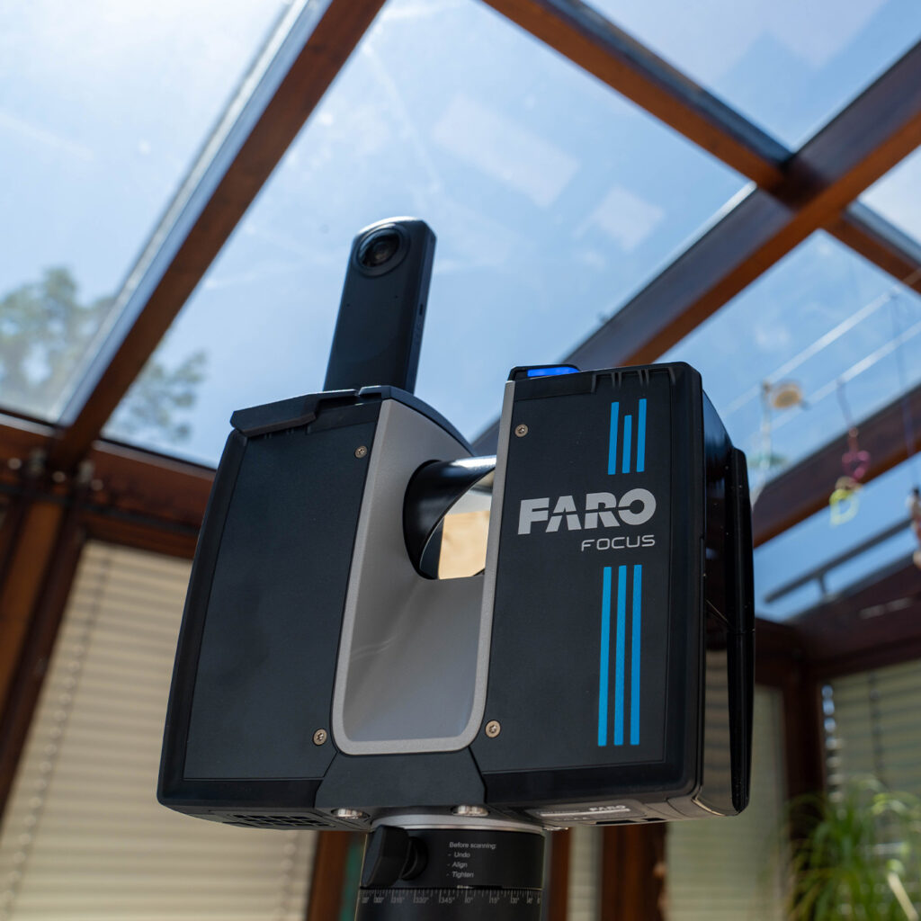 Schwarz-blauer 3D-Scanner mit auffälliger Struktur, stehend unter Glasdach.